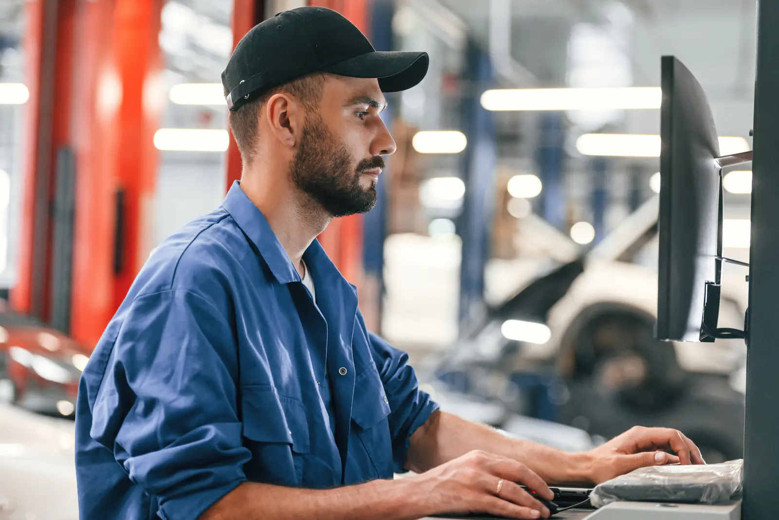 in-black-cap-using-computer-auto-mechanic-workin-2026-01-08-23-56-58-utc