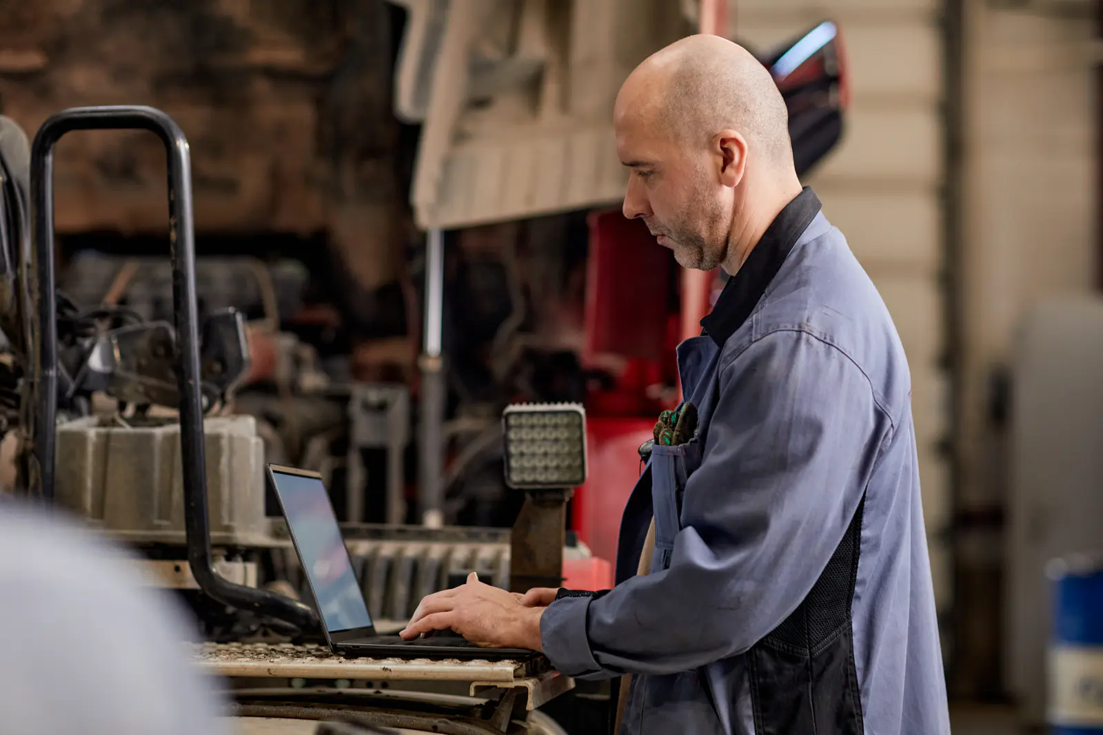 working-man-using-laptop-in-automotive-workshop-2026-01-08-08-11-23-utc